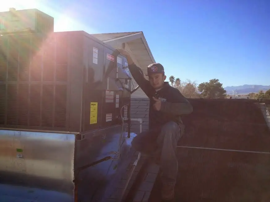 HVAC technician performing Air Duct Cleaning on a rooftop unit in Oak Park